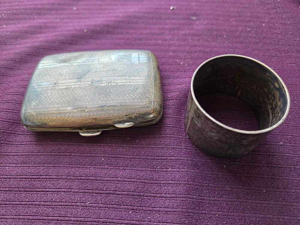 Lot 656 – Two silver items, comprising a George V sterling silver cigarette case and a Silver napkin ring 90g