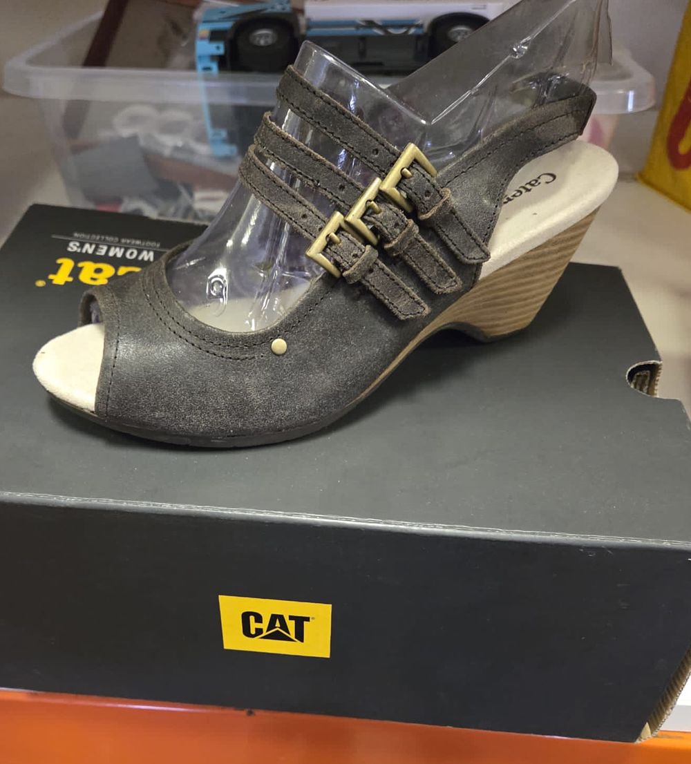 Lot 235 – A pair of Caterpillar women’s charcoal grey leather triple-strap wedge sandals