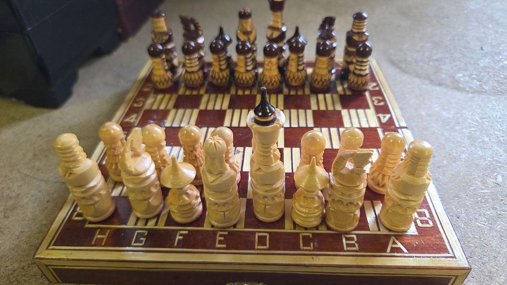 Lot 168 – A Folding Hand-carved Wooden Chess Set with Chip-carved Detailing