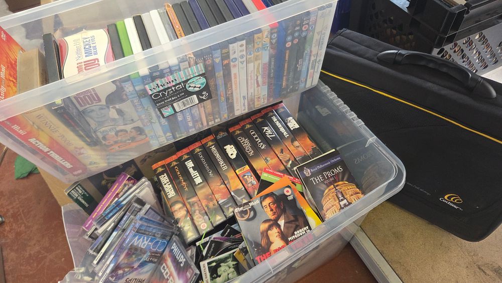 Lot 212 – Two Boxes of Mixed Home Media Including James Bond VHS Tapes DVDs and CDs