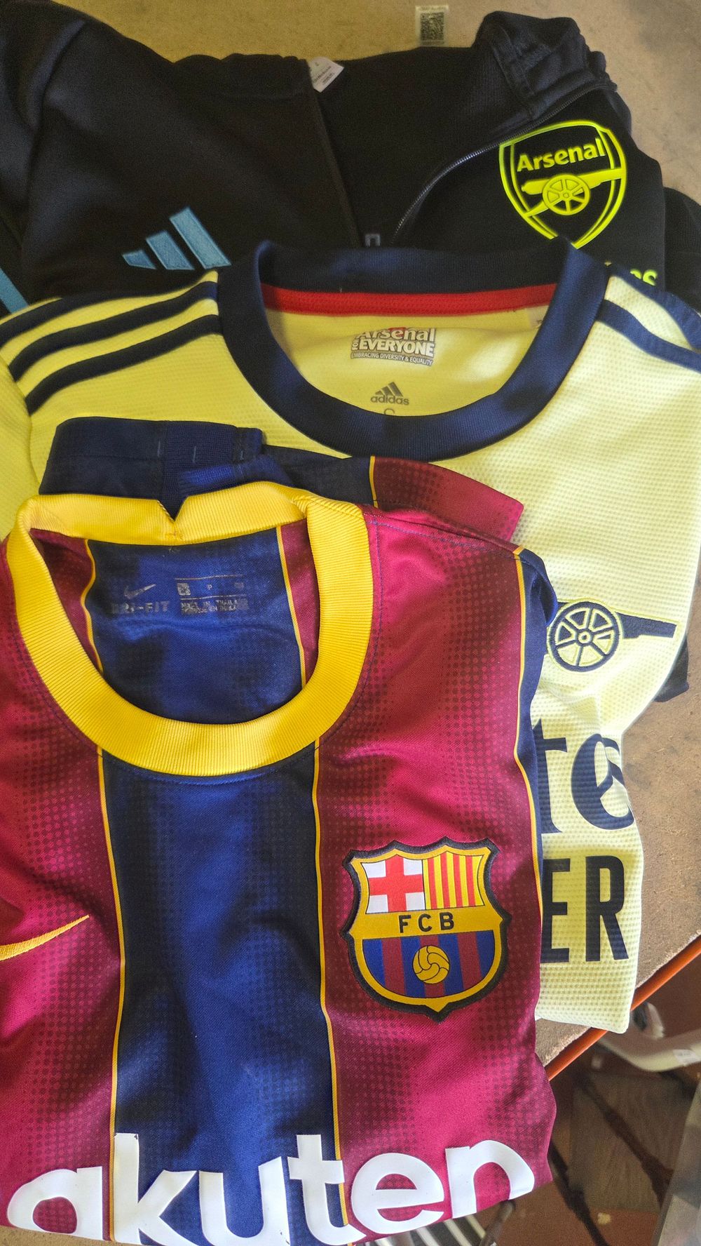 Lot 245 – A Trio of Modern Football Jerseys and Apparel, Arsenal FC and FC Barcelona