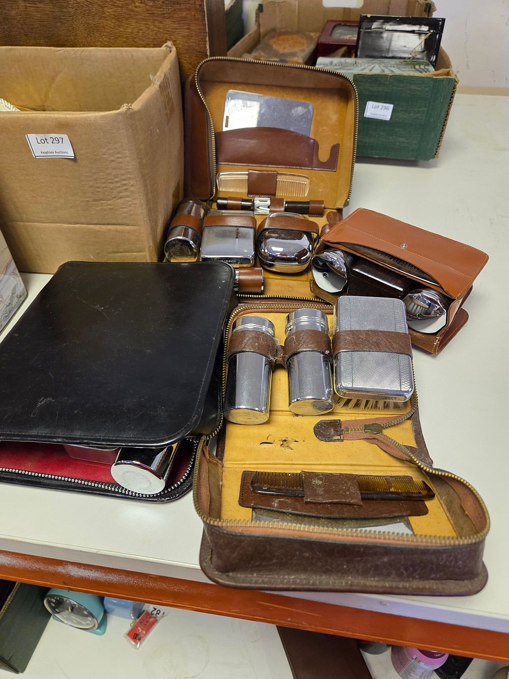 Lot 299 – A collection of mid-20th-century leather-cased gentlemen’s travel grooming and vanity sets