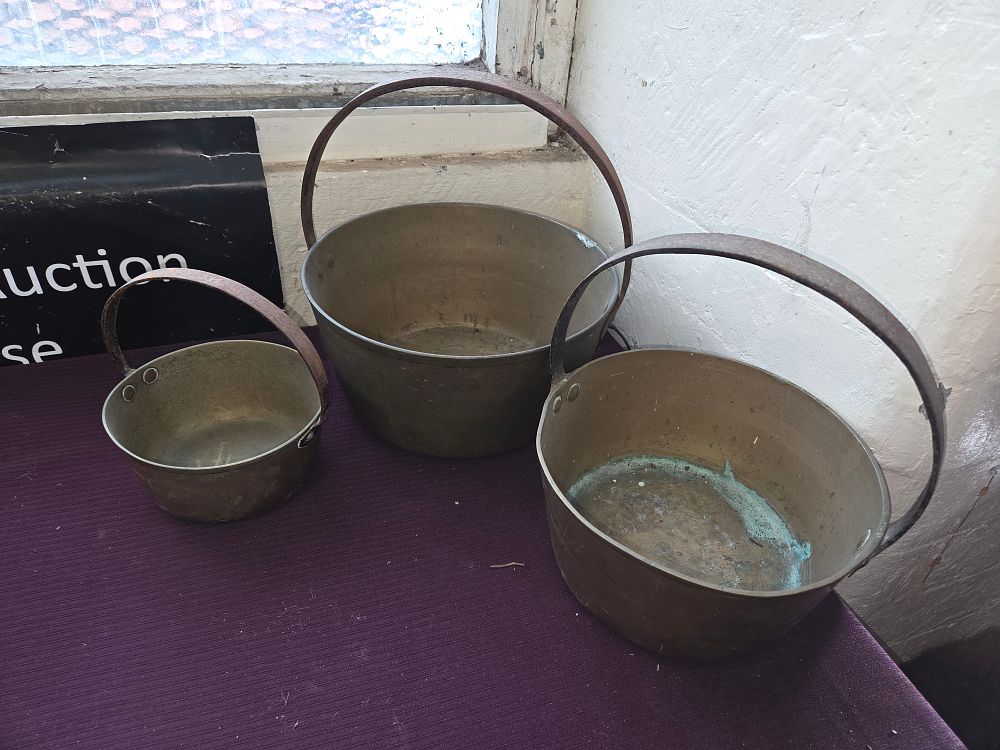 Lot 159 – Three graduated antique brass cooking pots with wrought iron handles