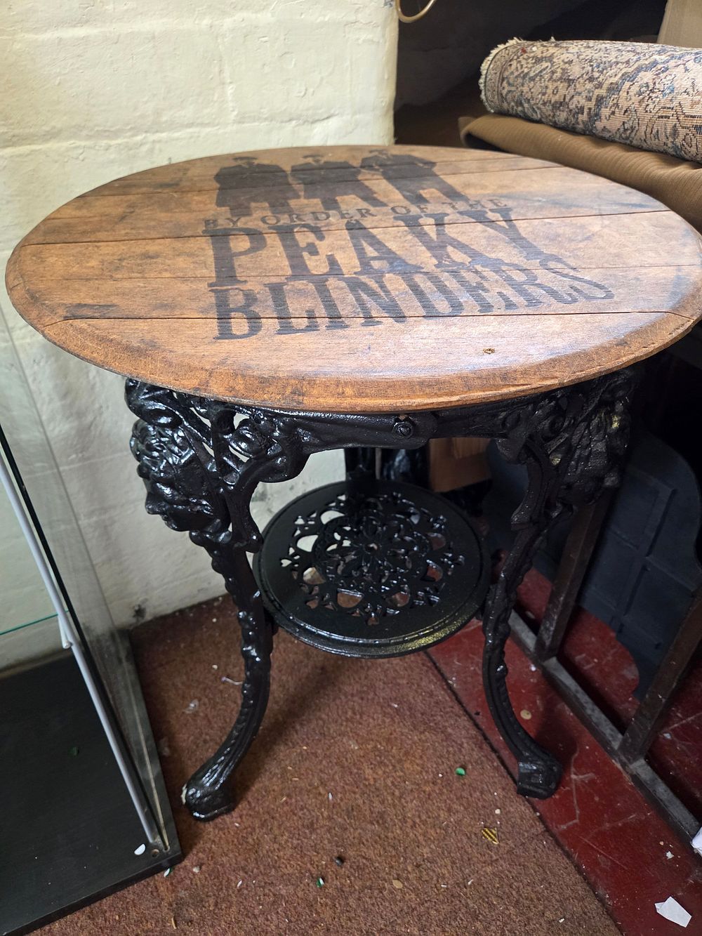 Lot 196 – Antique Round cast iron Britannia style bistro table with Peaky Blinders themed wooden top