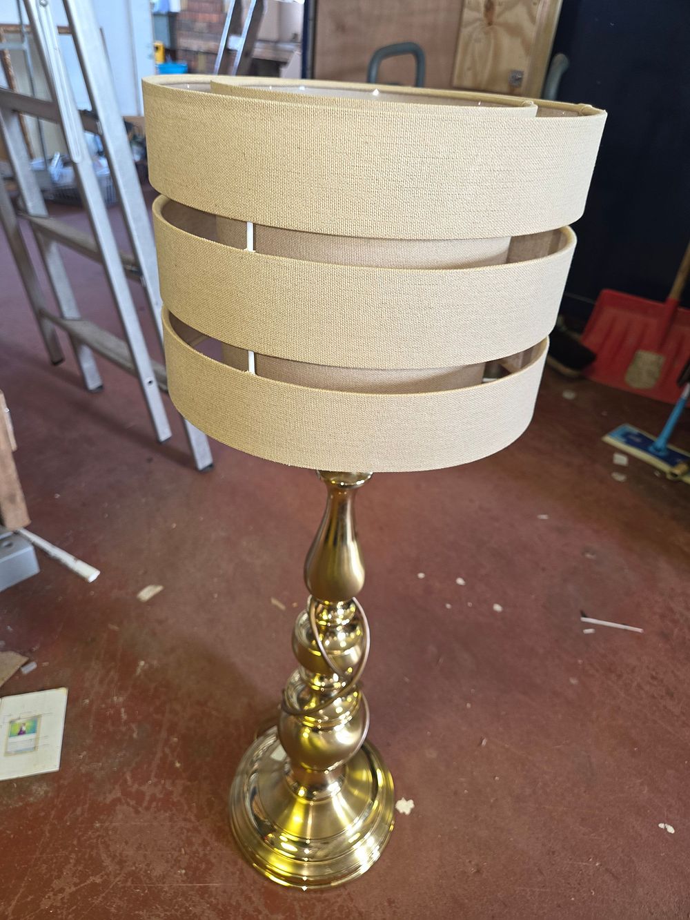 Lot 411 – A Contemporary Polished Brass-Tone Table Lamp with Three-Tier Banded Shade
