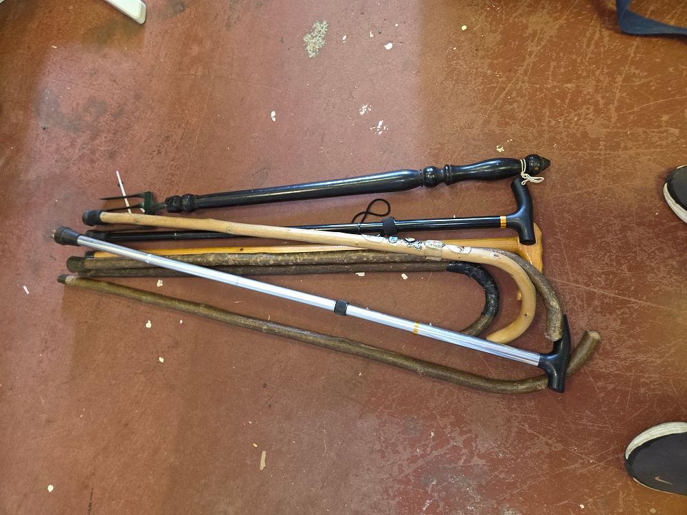Lot 413 – An Assortment of Six Walking Sticks, Canes, and a Garden Implement