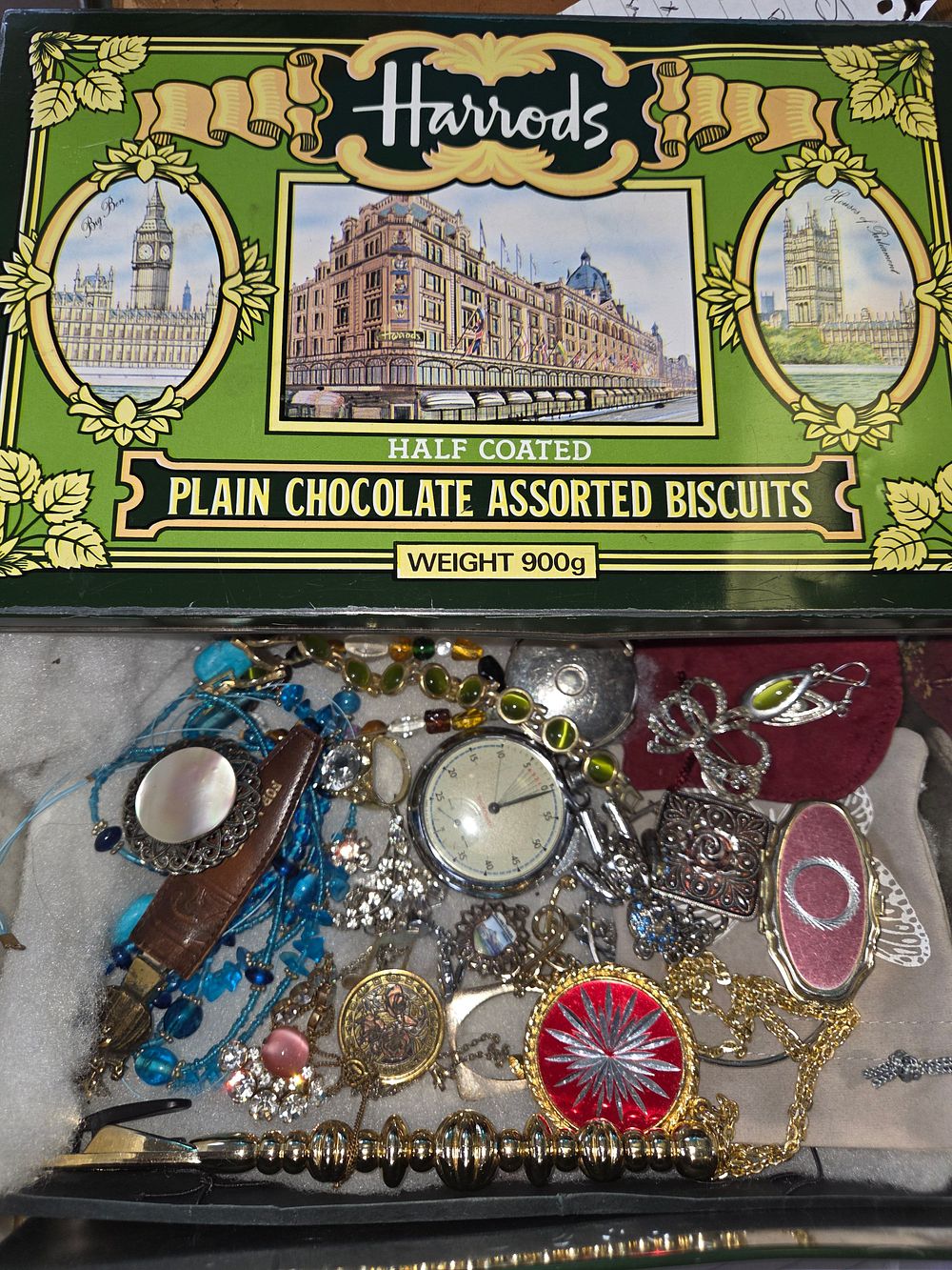 Lot 648 – An Assortment of Costume Jewellery and a Vintage Timepiece in a Harrods Biscuit Tin