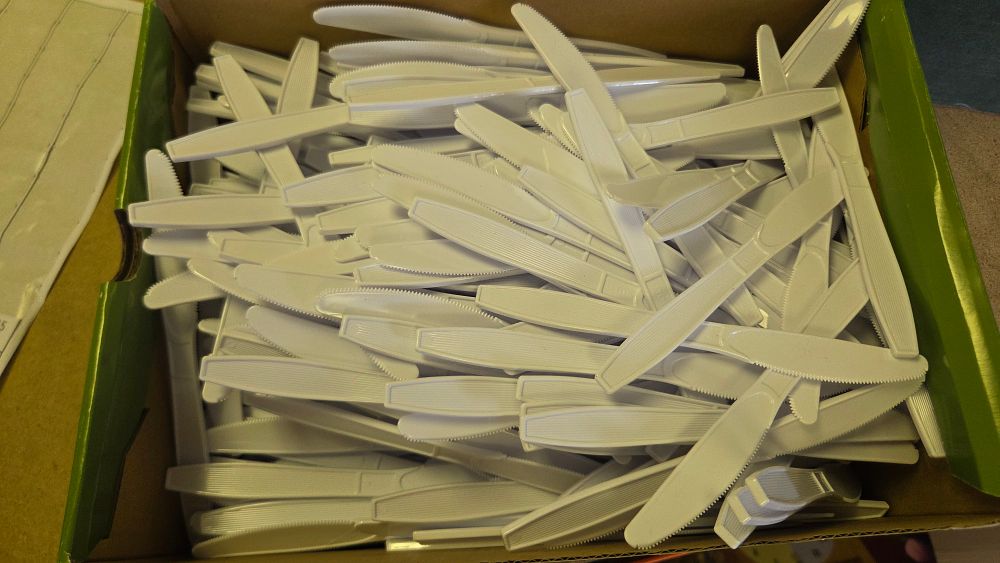 Lot 313 – A bulk lot of white plastic disposable knives