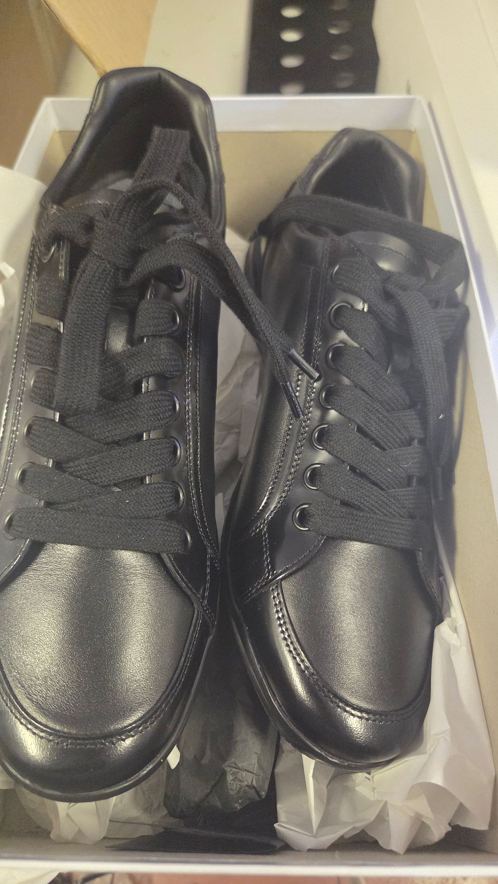 Lot 244 – A pair of black leather low-top trainers in the style of Prada