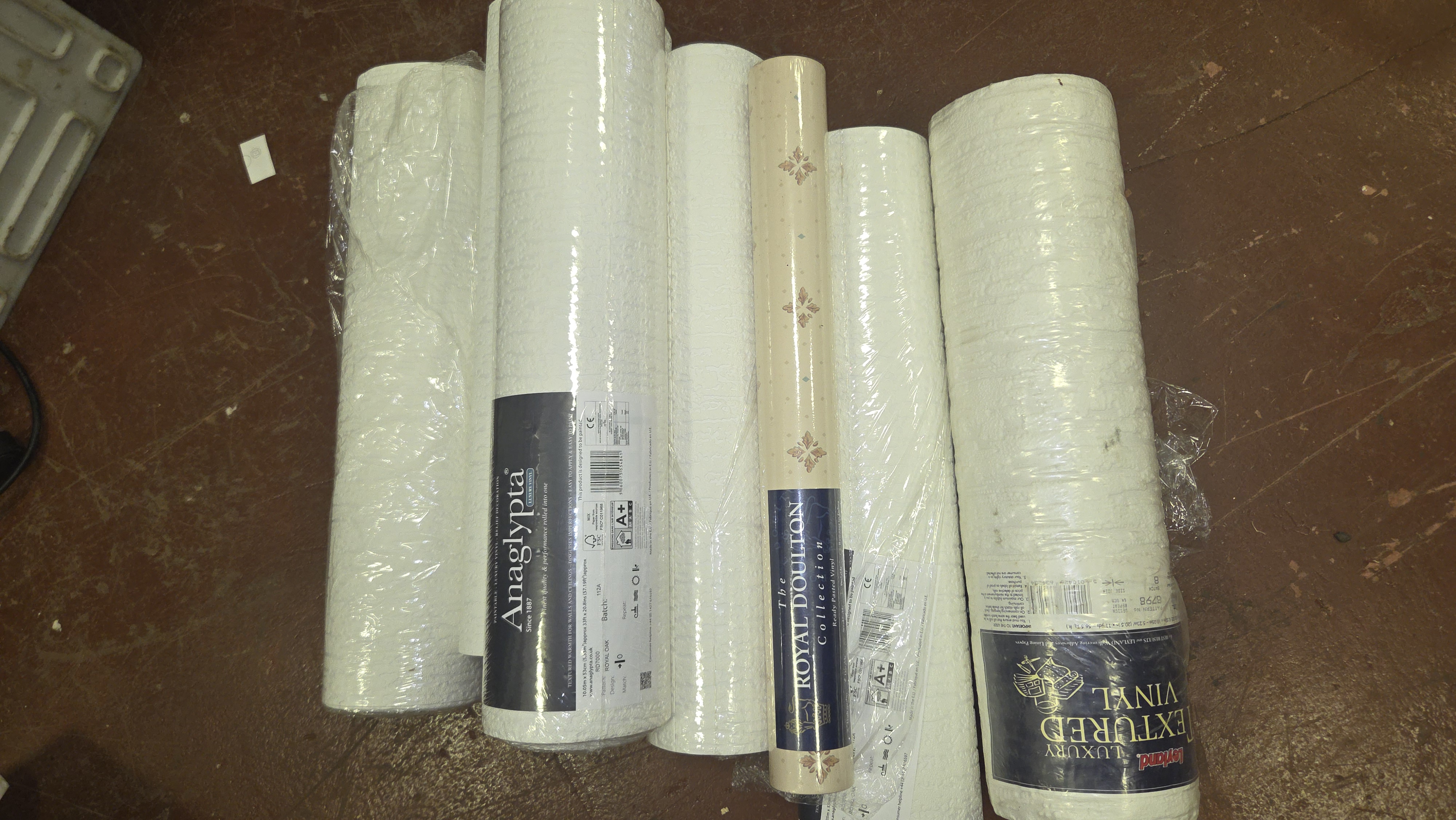 A Collection of Assorted Textured Vinyl Wallpaper Rolls including Anaglypta, Royal Doulton, and Leyland