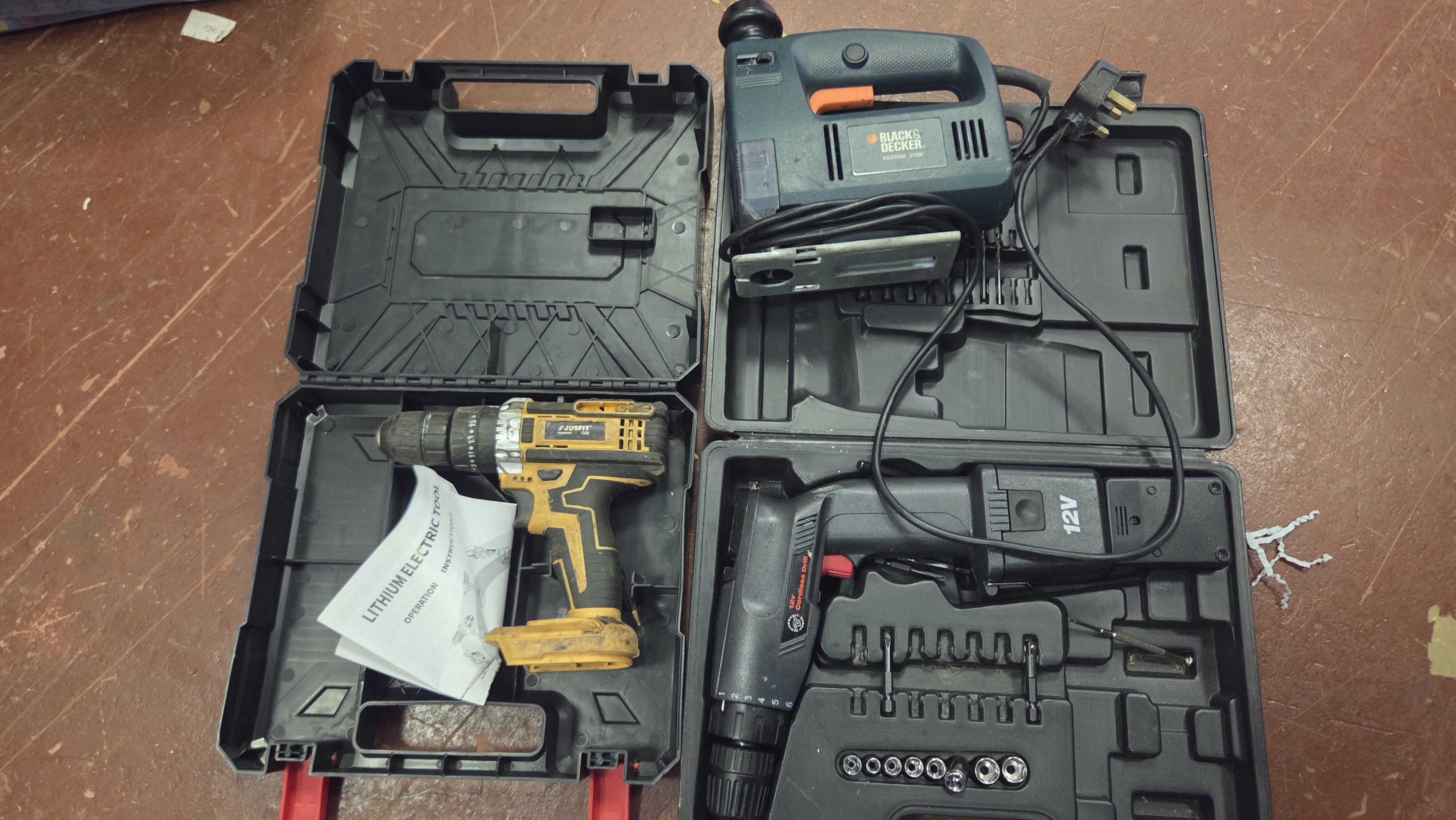 A Trio of Power Tools comprising a Black and Decker Jigsaw and Two Cordless Drills with Cases