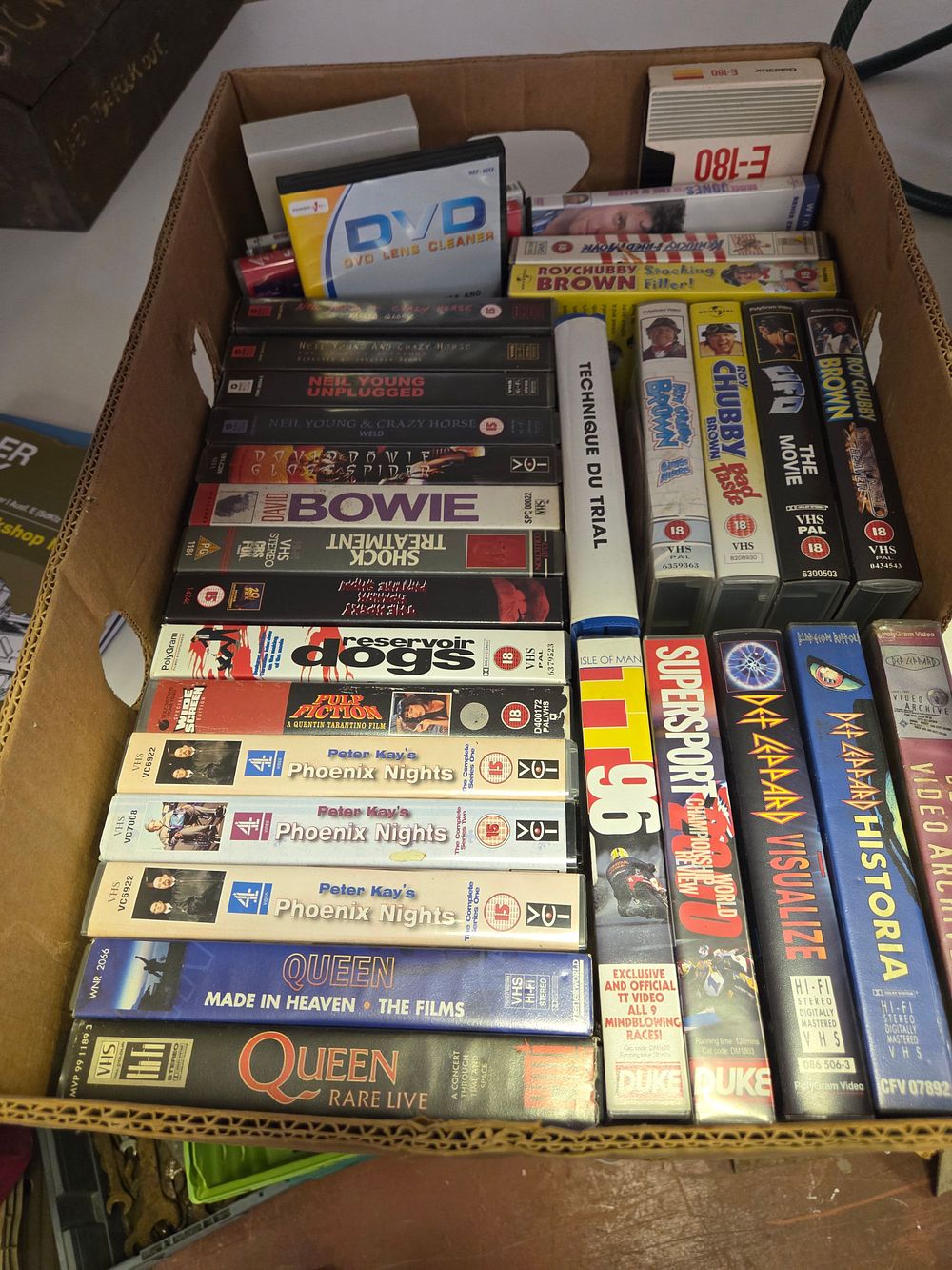 Lot 353 – A Collection of Music, Comedy, and Film VHS Tapes including Queen, David Bowie, and Phoenix Nights