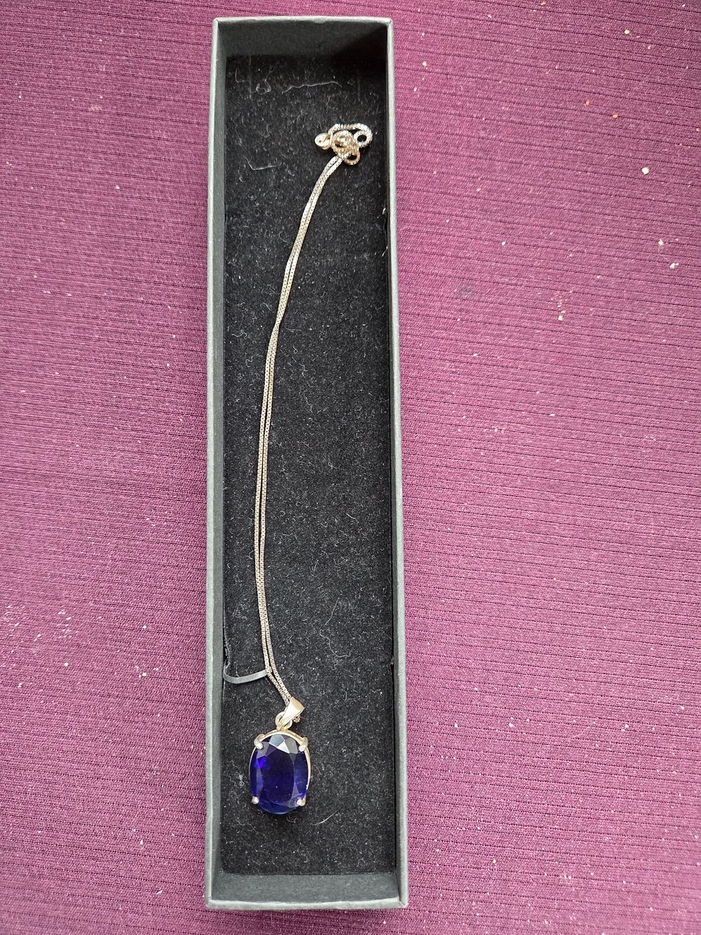 Lot 643 – An Oval Cut Blue Tanzanite Solitaire Pendant on a 925 Silver Box Link Chain 6.16g
