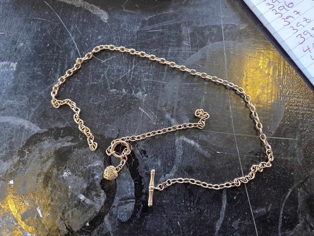 Lot 639 – A 9 Carat Yellow Gold Oval Link Necklace with T-Bar Clasp and Heart Charm 6.44g