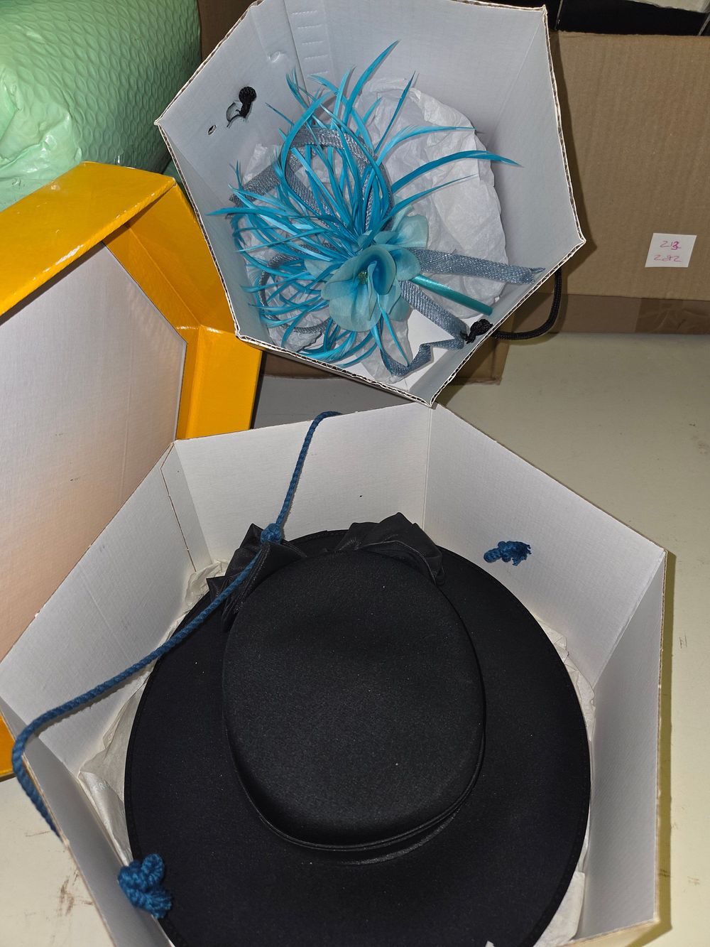 Lot 211 – Black Wide-Brimmed Hat and a Blue Feathered Fascinator in Hat Boxes