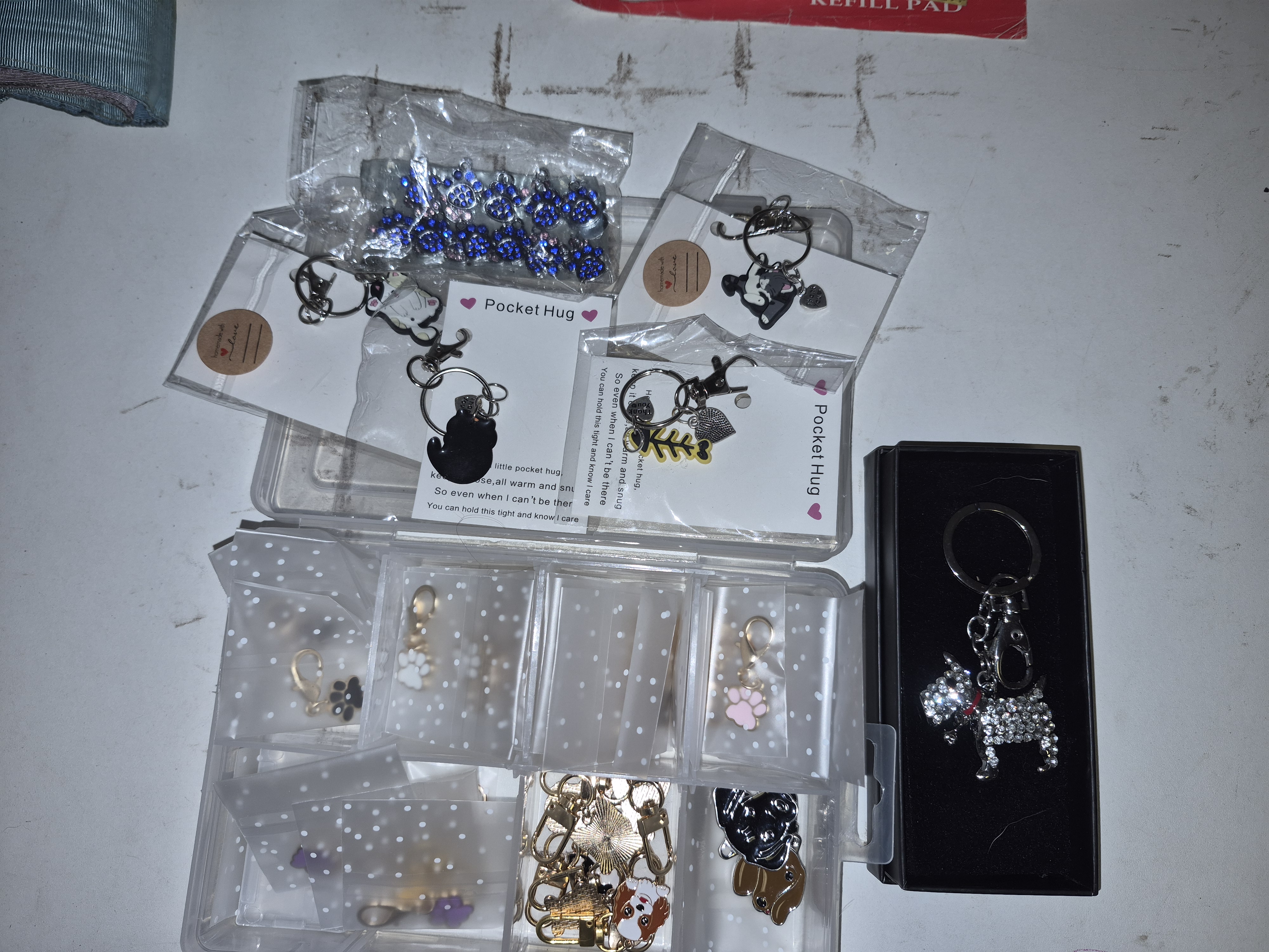 An Assortment of Novelty Keyrings and Costume Jewellery Charms Including Pocket Hug Cards