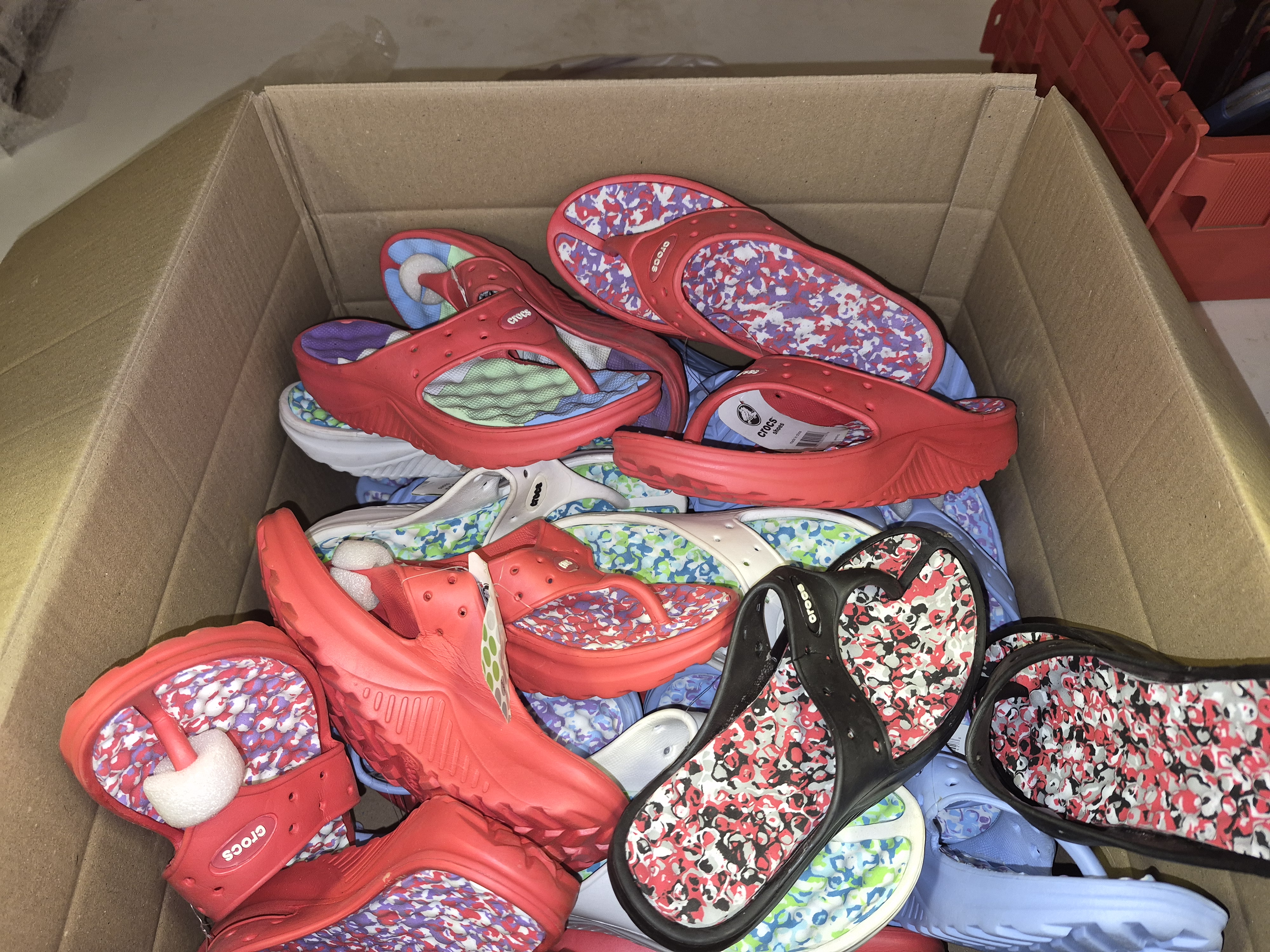 Box of New Crocs Flip-flops in various sizes
