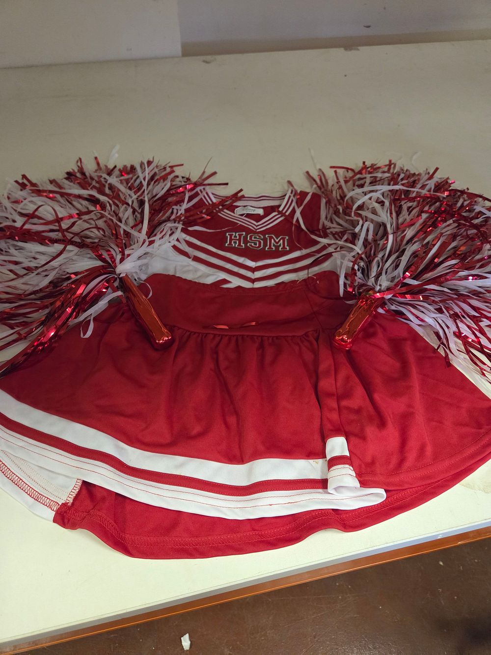 Lot 231 – One High School Musical Cheerleader Costume and A Pair of Pom-poms aged 7-8yrs