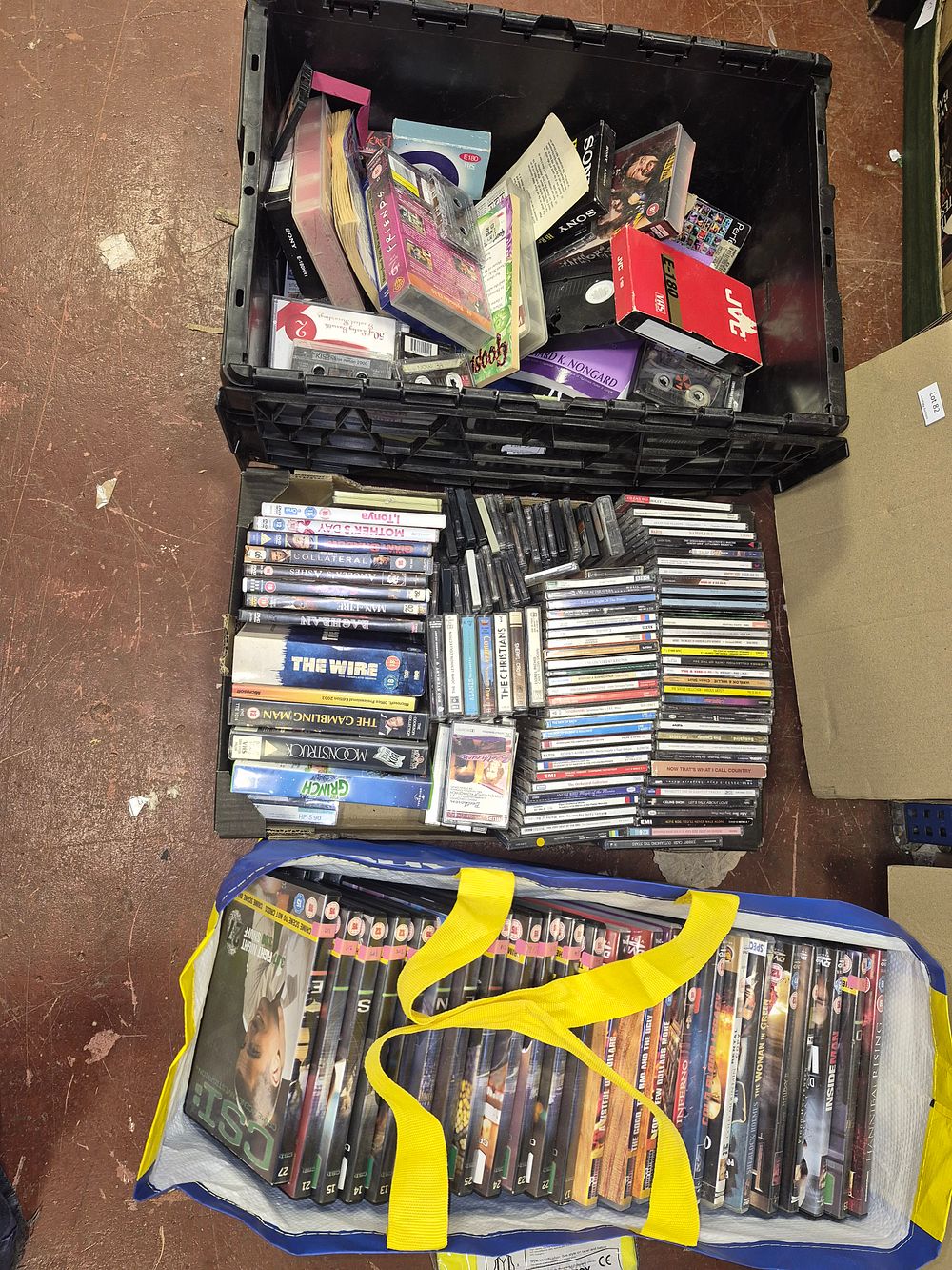 Lot 79 – Two Boxes and Bag of DVDs, CDs, VHS Tapes, and Audio Cassettes Including CSI, The Wire, and The Good, The Bad and The Ugly