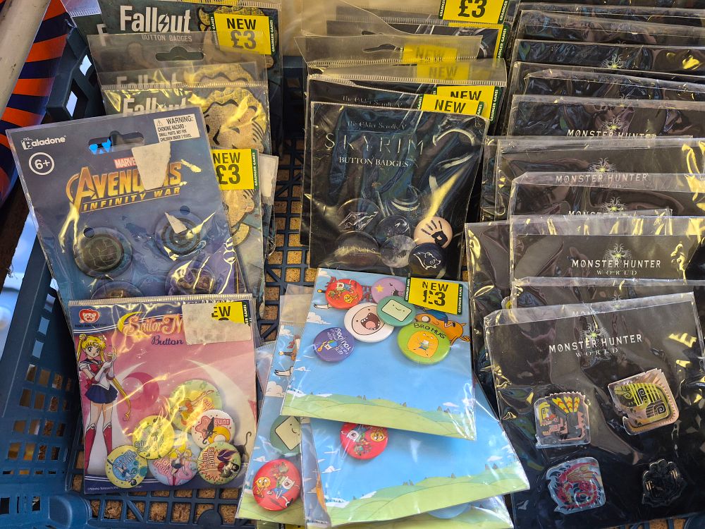 Lot 168 – A Collection of Paladone and Toei Animation Button Badges and Enamel Pins featuring Fallout, Skyrim, and Monster Hunter