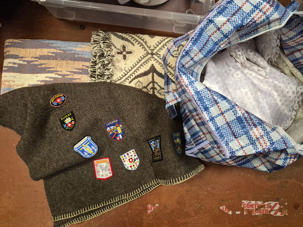 Lot 18 – An Assortment of Vintage Textiles Including a Wool Souvenir Blanket with European Travel Patches