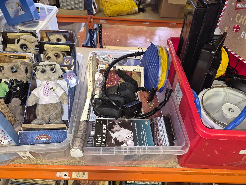 Lot 102 – Three Boxes of Mixed Household Items. Inc Compare the Market Meerkats and Media