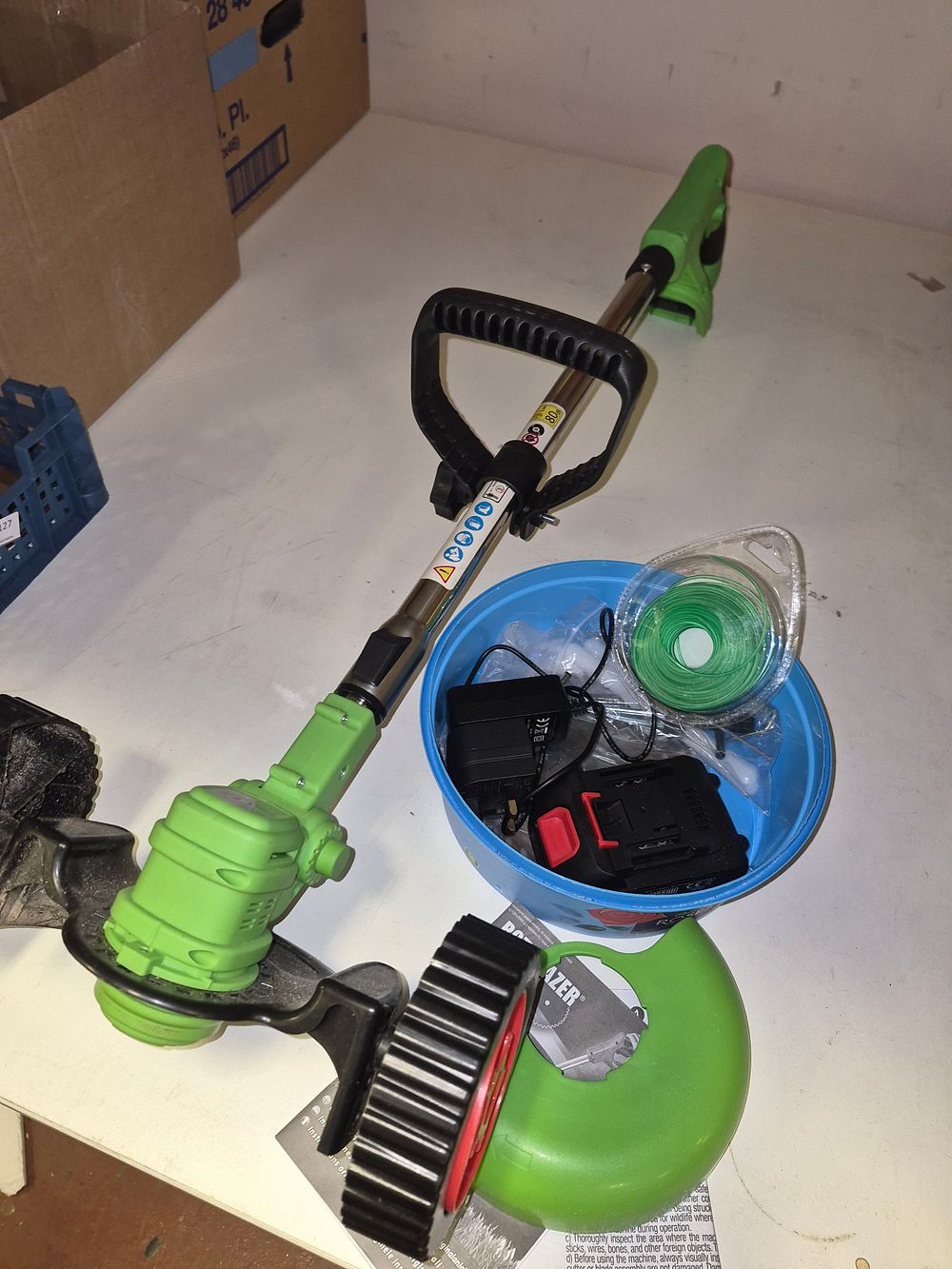 Lot 285 – Cordless Grass Trimmer with Battery, Charger, and Accessories powers on