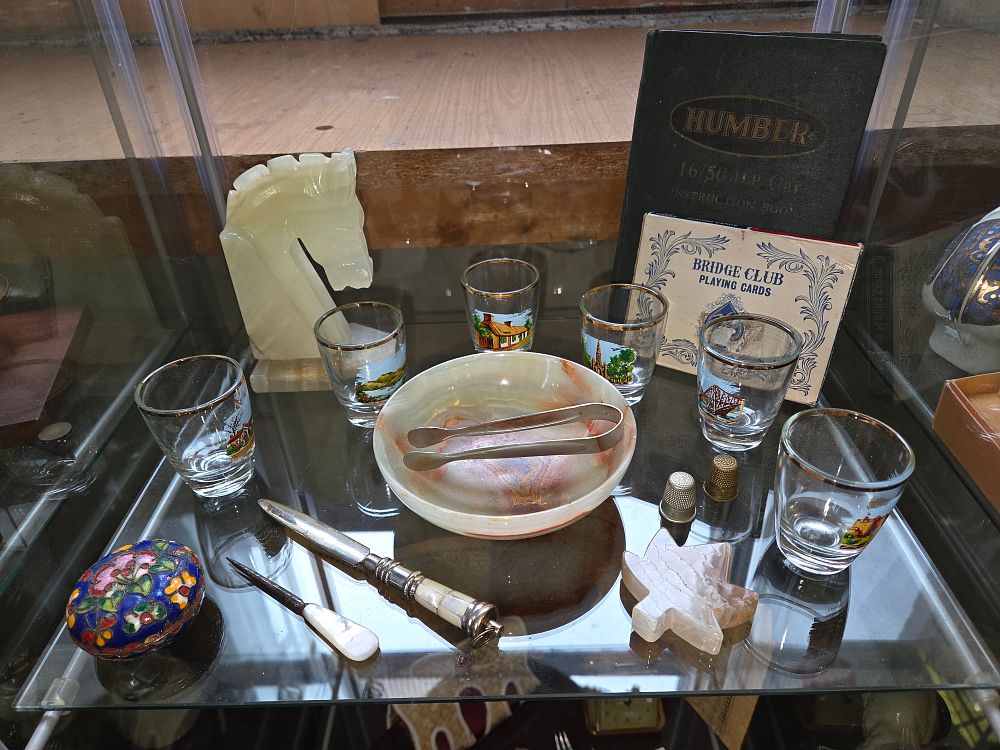 Lot 617 – An Assortment of Decorative Onyx Objects, Souvenir Glassware, and Desk Accessories Including Humber Car Manual