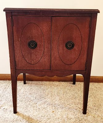 A Mid-20th Century Mahogany Toned Two-Door Cabinet. This mid-20th-century wooden two-door 