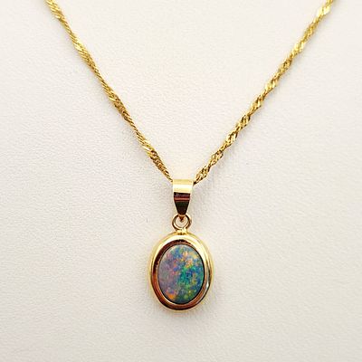14K Gold Opal Necklace 1.8 Grams. This necklace features an oval cabochon opal pendant bezel-set 