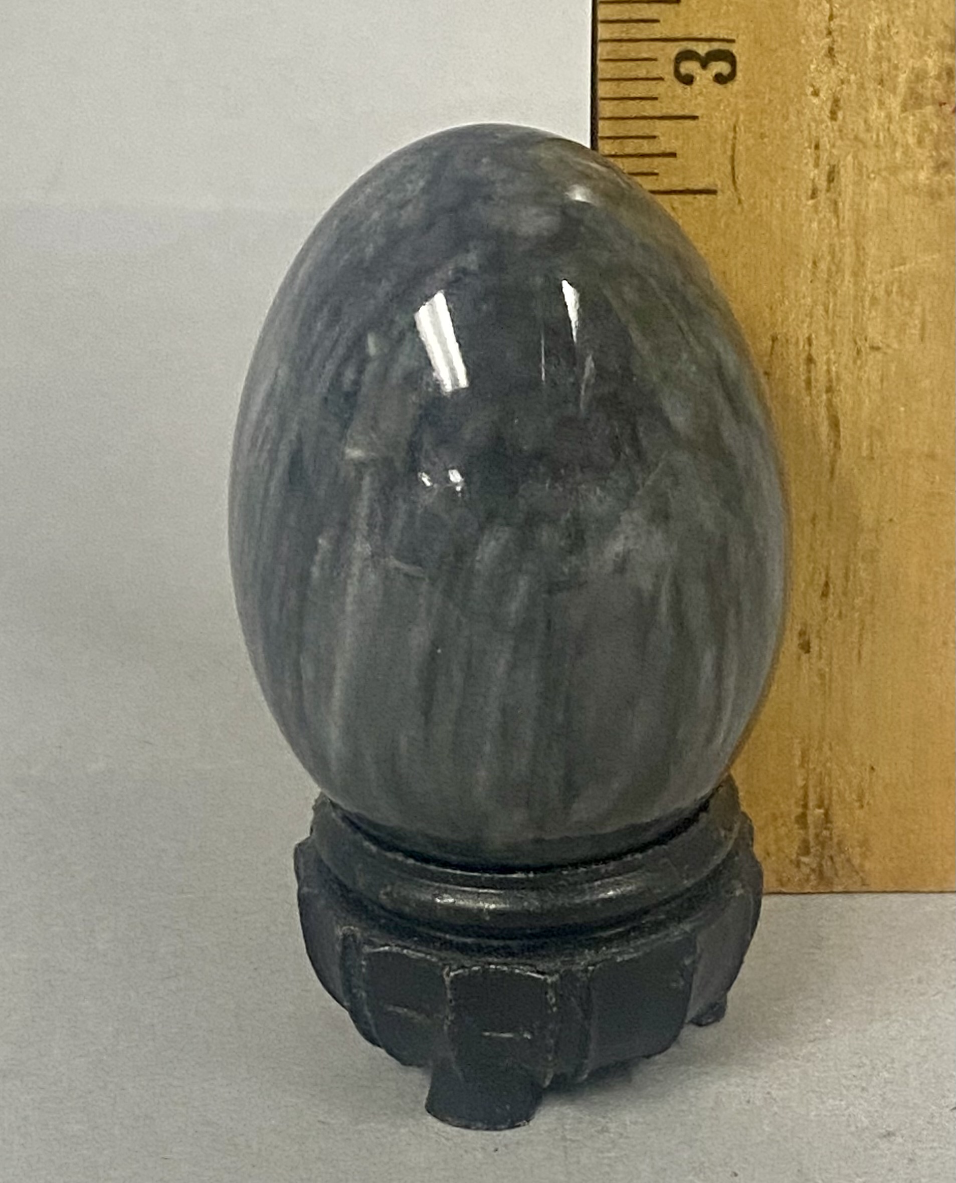 Polished Mottled Gray Stone Egg on a Carved Wooden Stand