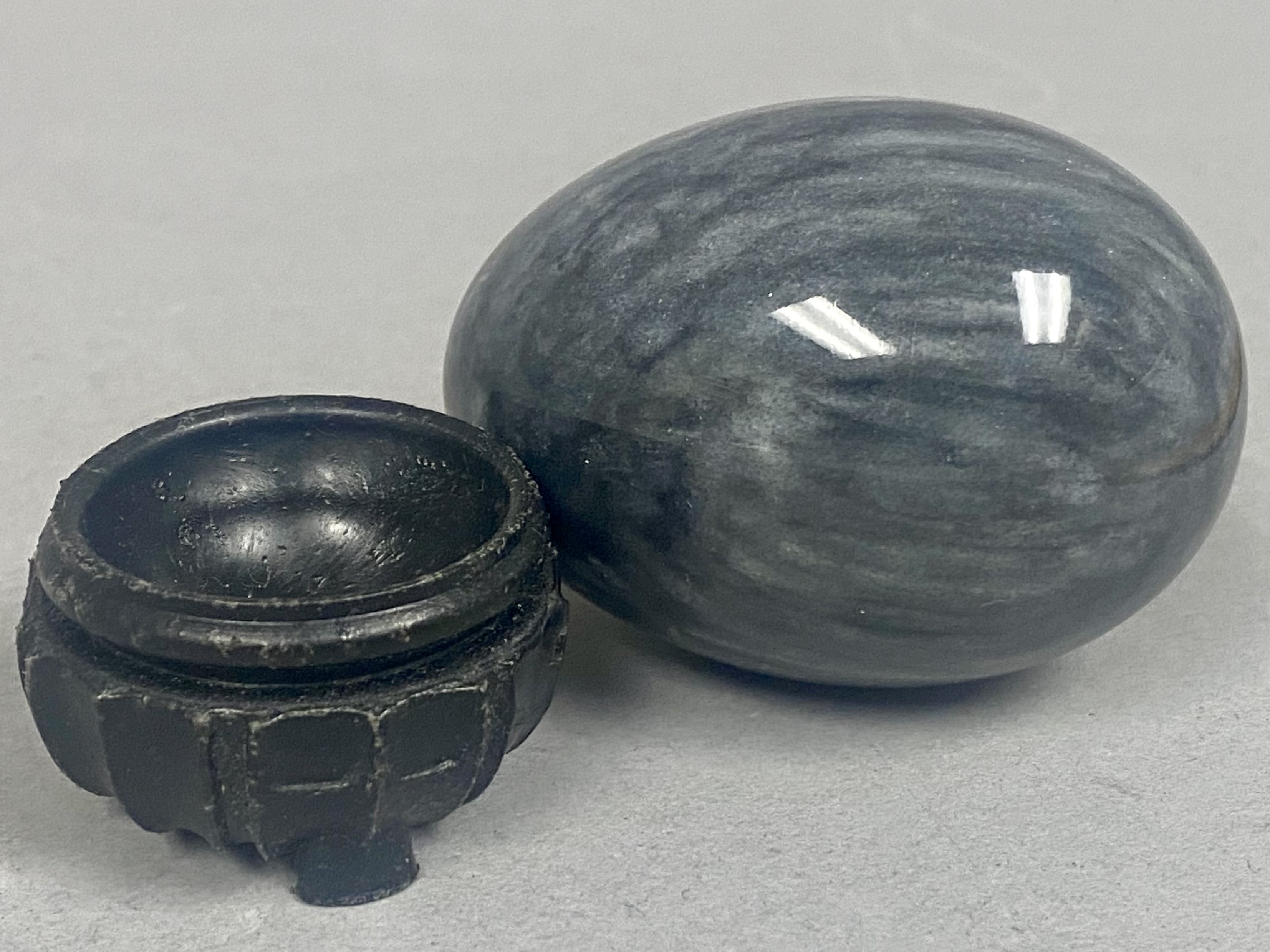 Polished Mottled Gray Stone Egg on a Carved Wooden Stand