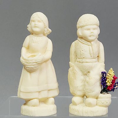 Carved Bone Dutch Figurines. A pair of hand-carved bone figurines depicting a young boy and girl 