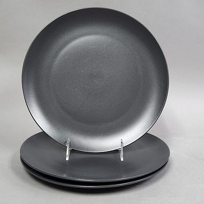 Ikea Matte Black Stoneware Plates. A trio of circular stoneware plates featuring a minimalist 