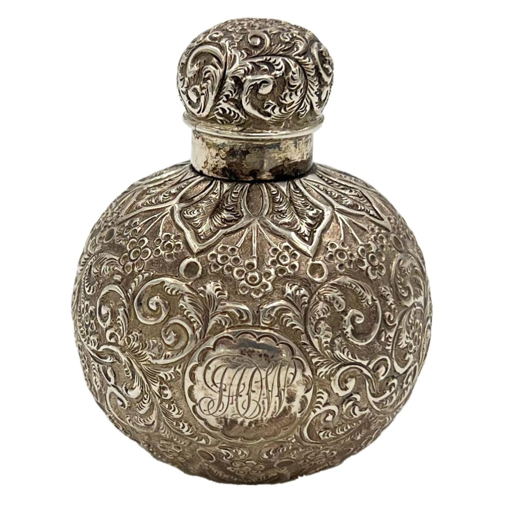 Lot 187: A SILVER LID PERFUME BOTTLE WITH EMBOSSED DECORATION...