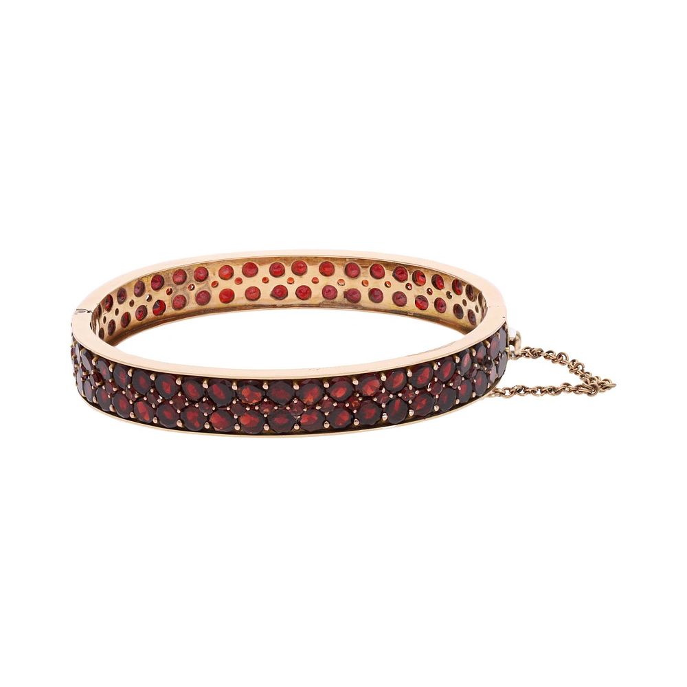 Lot 507: Heavy 9ct Gold and Garnet Bangle.