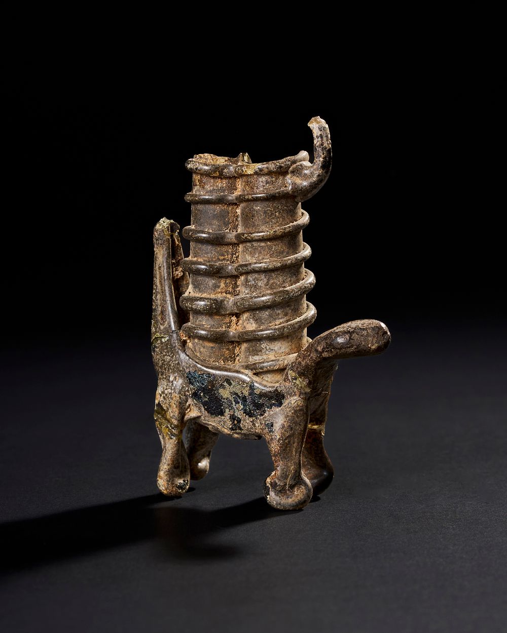 Lot 203: A RARE 8TH-9TH CENTURY SYRIAN UMAYYAD CAMEL-SHAPED MEDICINAL GLASS VESSEL