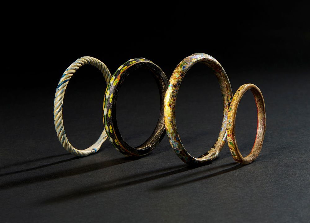 Lot 168: FOUR EARLY ISLAMIC GLASS BANGLES ABBASID CALIPHATE, POSSIBLY SYRIA OR IRAN, 7TH - 9TH CENTURY