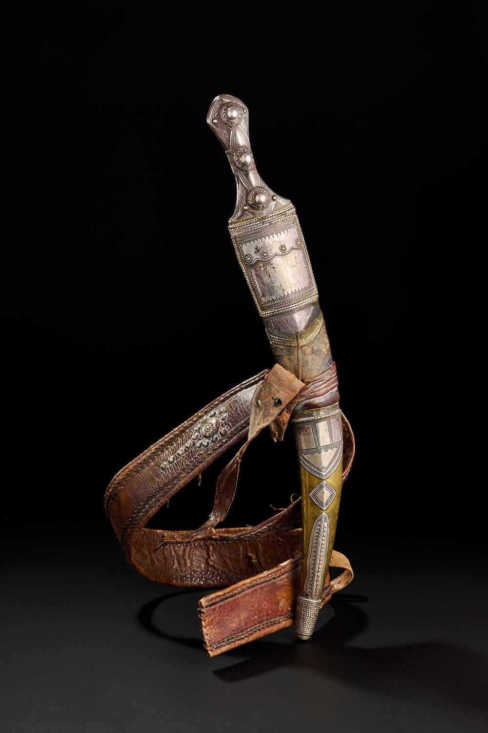 Lot 190: A LARGE SAUDI (WAHABI) HORN HILTED SILVER OVERLAID DAGGER WITH LEATHER BELT, 19TH CENTURY