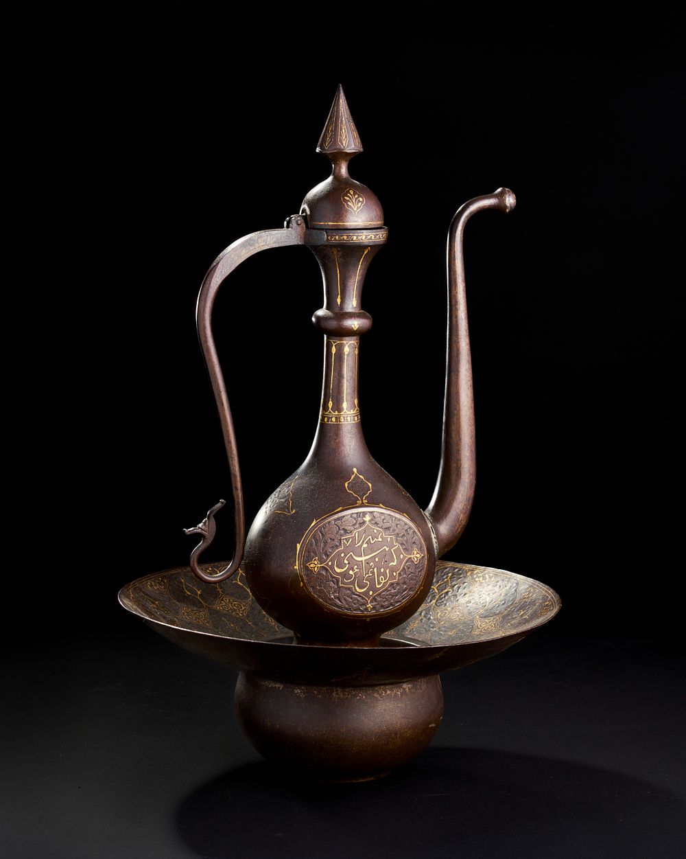 Lot 236: A QAJAR ENGRAVED GOLD-DAMASCENED STEEL EWER (AFTABAH) AND BASIN, 19TH CENTURY