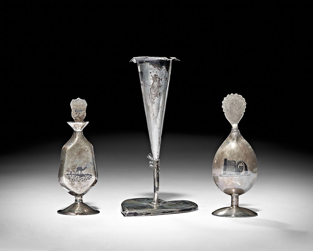 Lot 246: A GROUP OF IRAQI SILVER AND NIELLO CONSIST OF CANDLESTICK AND TWO DISPENSERS, 20TH CENTURY