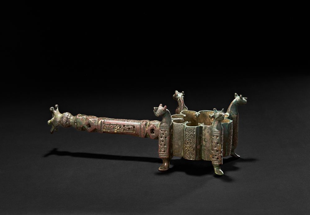 Lot 205: A BRONZE SELJUK INCENSE BURNER WITH LONG HANDLE AND LION HEADS FINIALS, 13TH CENTURY