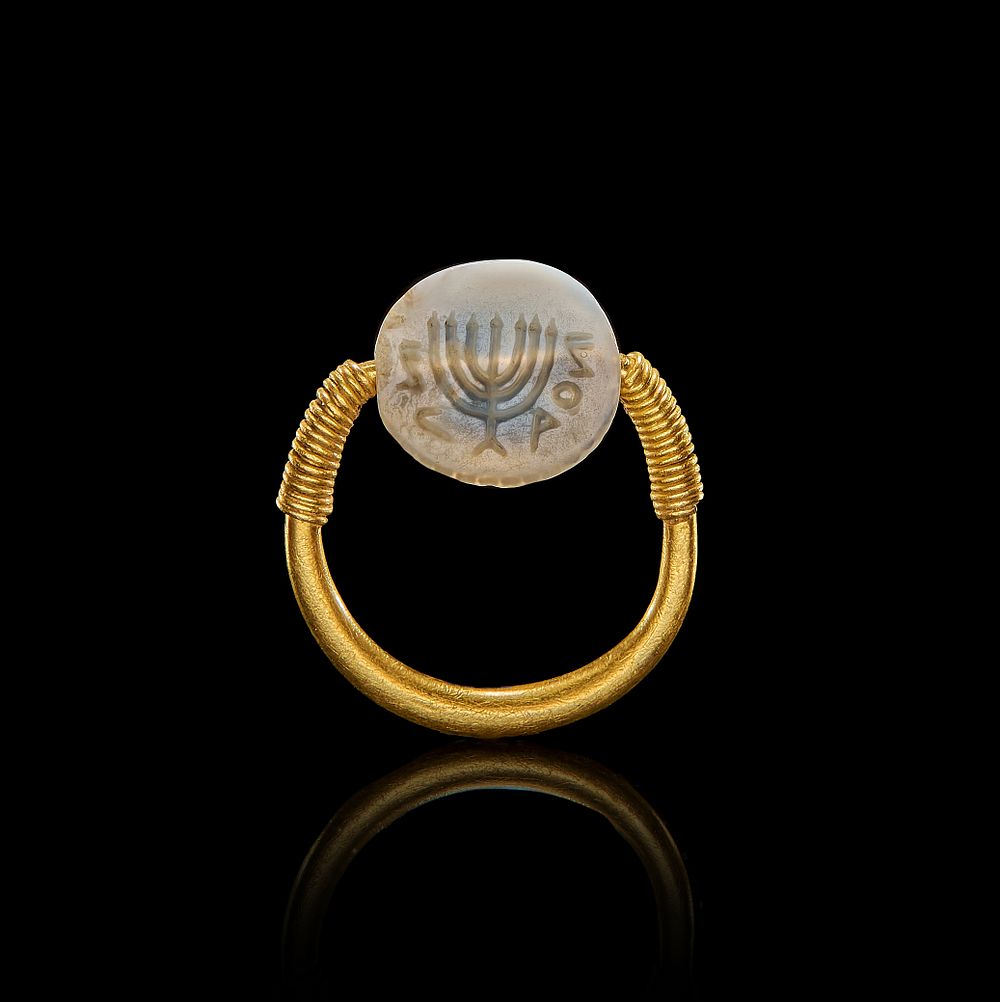 Lot 70: A HEBREW PHOENICIAN STAMP SEAL IN A GOLD RING DEPICTING MENORAH, POSSIBLY 600 B.C