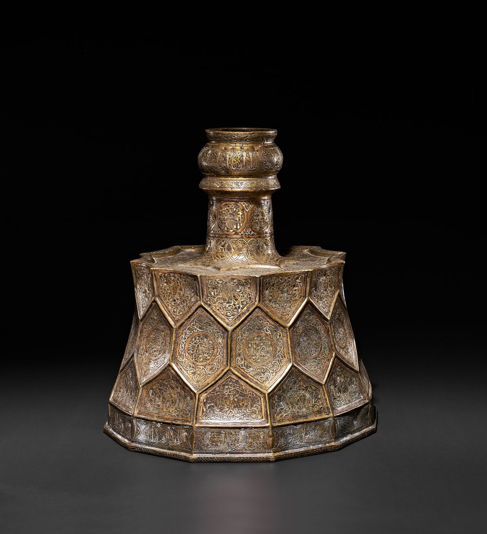 Lot 147: A MONUMENTAL SELJUK STYLE SILVER AND COPPER INLAID CANDLESTICK, 19TH CENTURY
