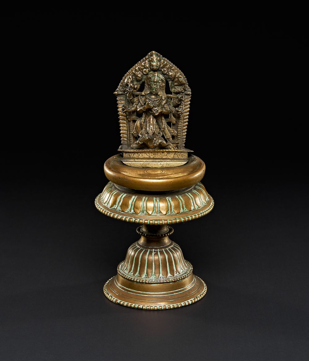 Lot 207: A BRONZE DEITY MOUNTED ON AN OFFERING STAND, TIBETAN OR NEPALESE, 17TH - 18TH CENTURY