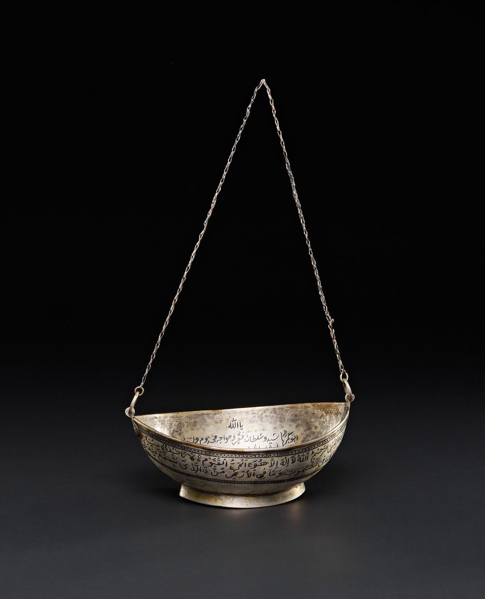 Lot 200: A RARE IRAQI NIELLO INLAID WHITE METAL SUFI KASHKUL WITH QURANIC VERSES, 19TH CENTURY