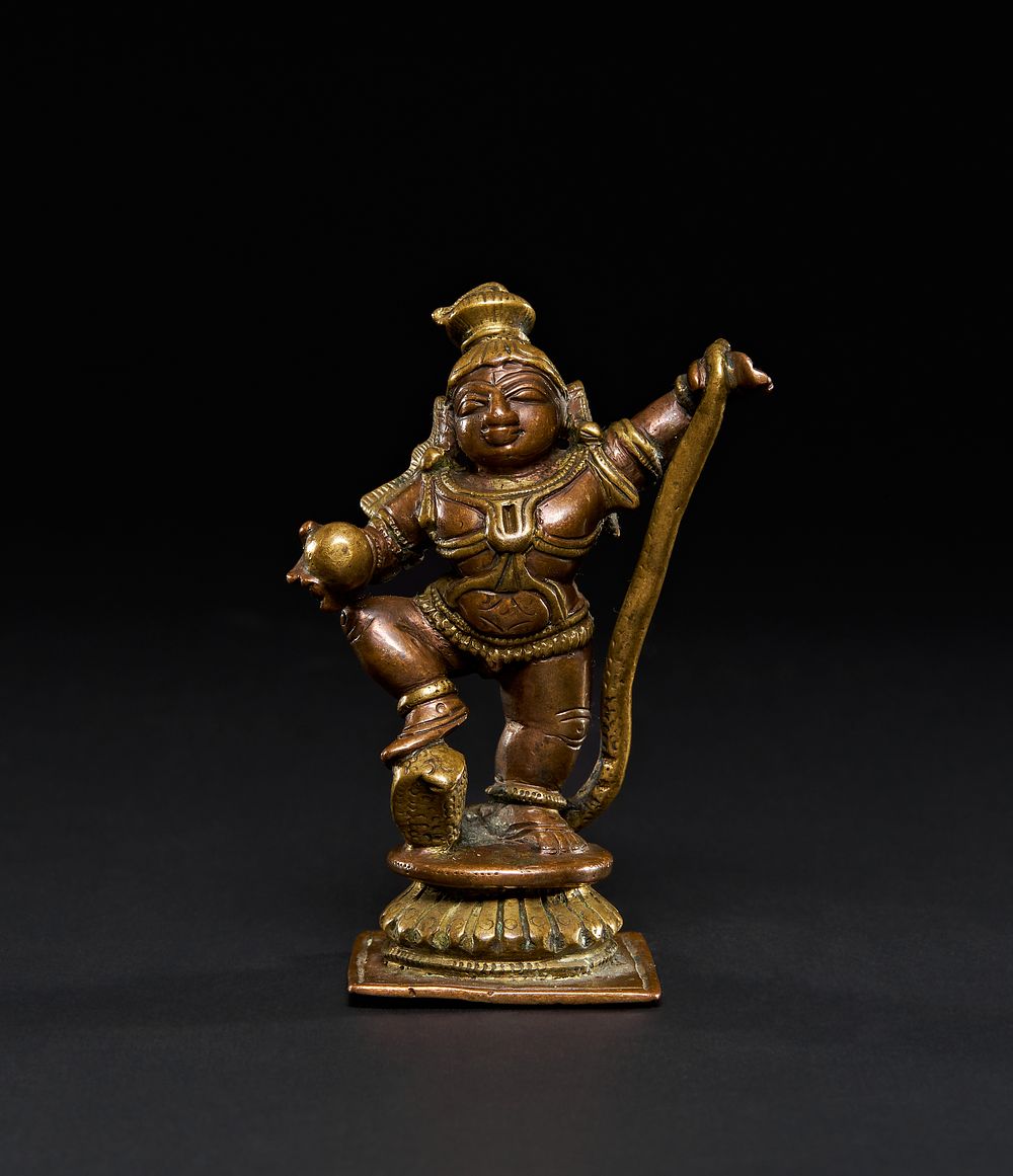 Lot 211: A SOUTH INDIAN TANJORE BRASS AND COPPER GANGA JAMUNA FIGURE OF KRISHNA THE BUTTER THIEF, 19TH CENTURY