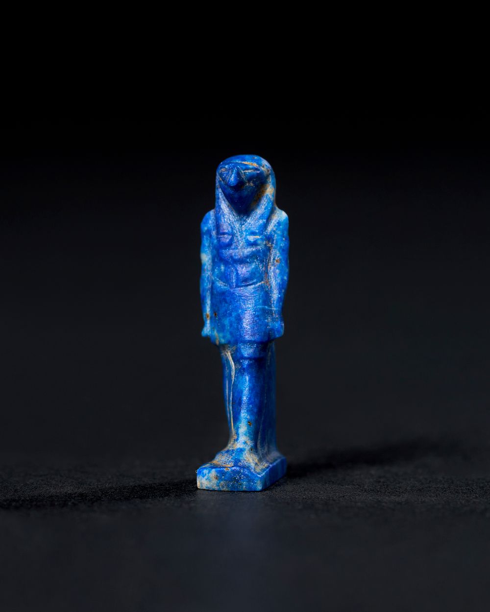 Lot 95: AN EGYPTIAN LAPIS LAZULI AMULET, DEPICTING A FALCON-HEADED DEITY, LATE PERIOD TO PTOLEMAIC PERIOD, 664-30 B.C.