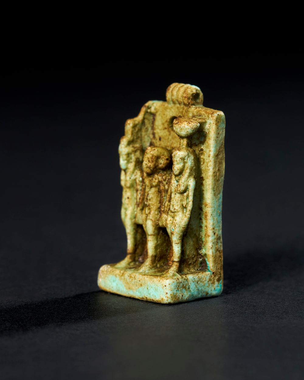 Lot 97: AN EGYPTIAN FAIENCE AMULET DEPICTING THE TRIAD OF GODS, LATE PERIOD TO PTOLEMAIC PERIOD, 664-30 B.C.