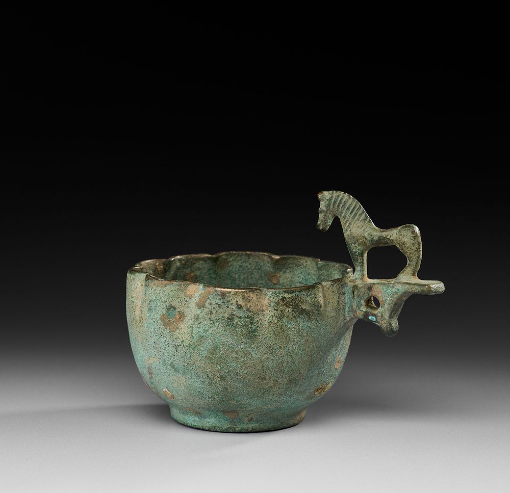 Lot 218: AN EARLY ISLAMIC PERSIAN HIGH TIN BRONZE CUP WITH HORSE HANDLE, 7TH - 8TH CENTURY